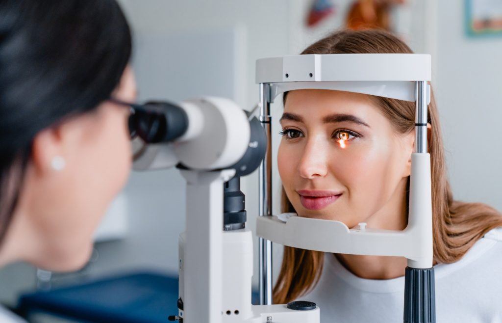 eye doctor testing female patients eyes